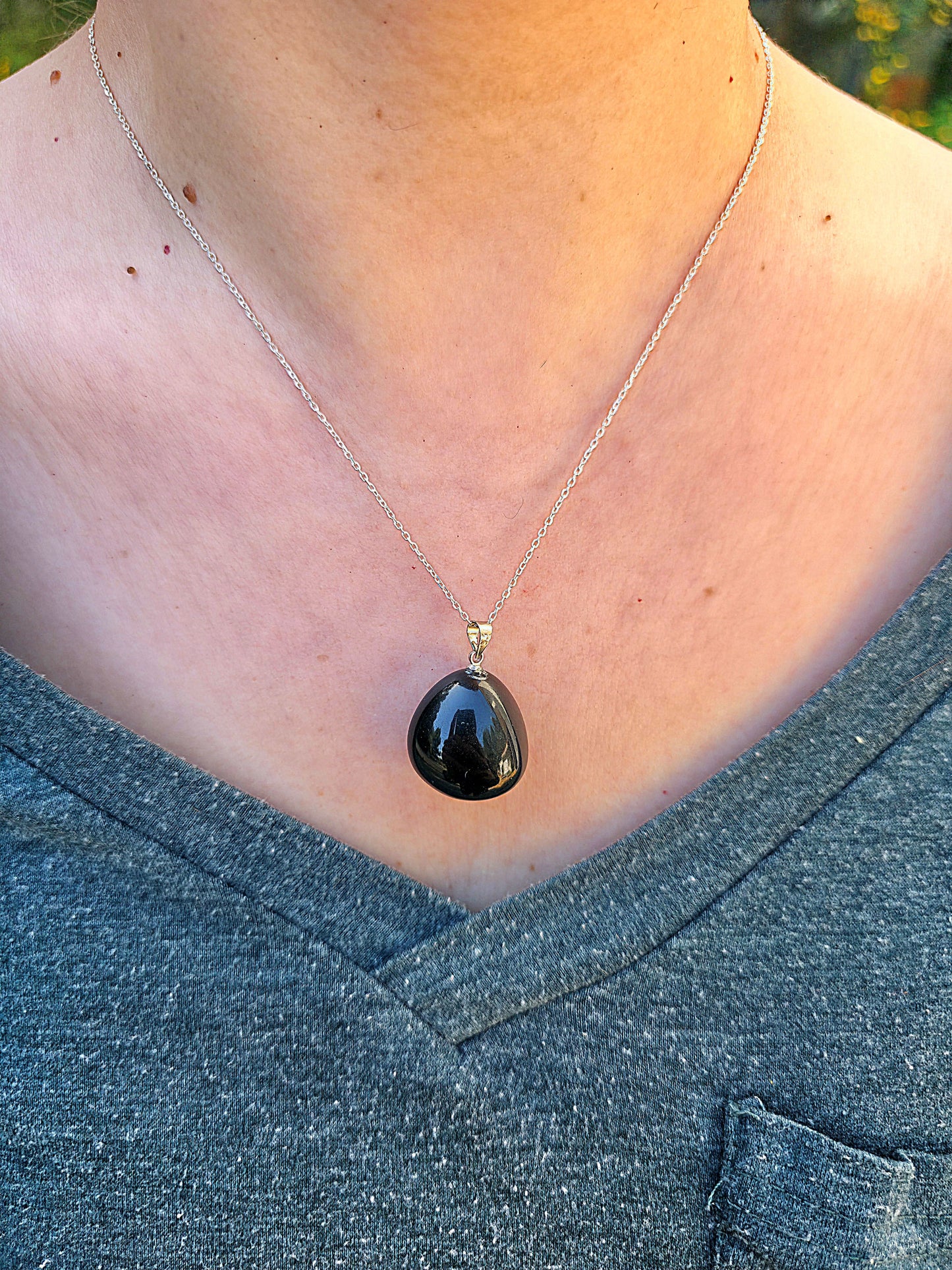 Colgante de Obsidiana Ojo Celestial rodado natural, superficie negra con destellos iridiscentes con cadena de plata