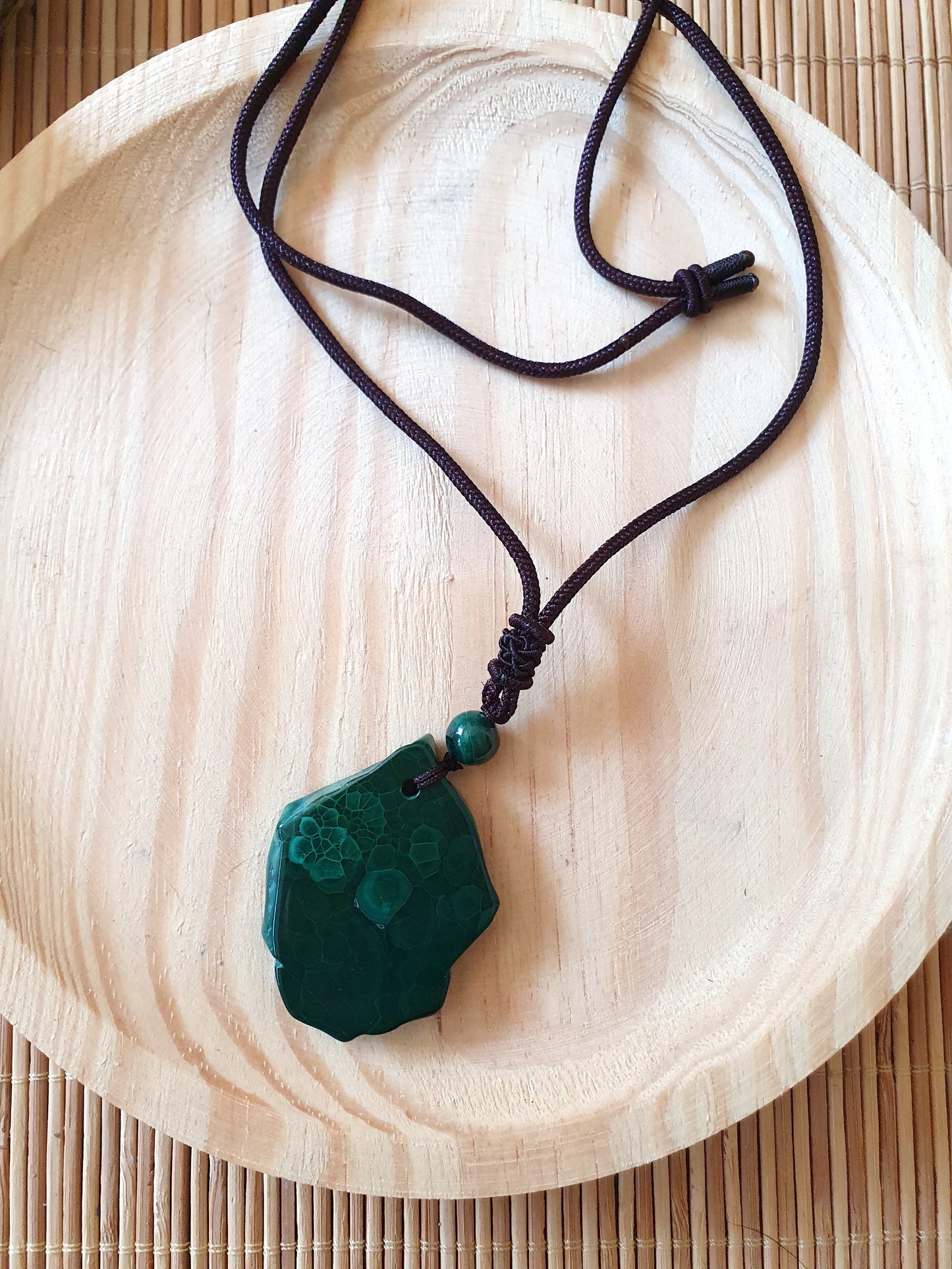 Colgante de Malaquita natural en rodaja, piedra plana verde con vetas únicas y cordón negro que se ajusta.