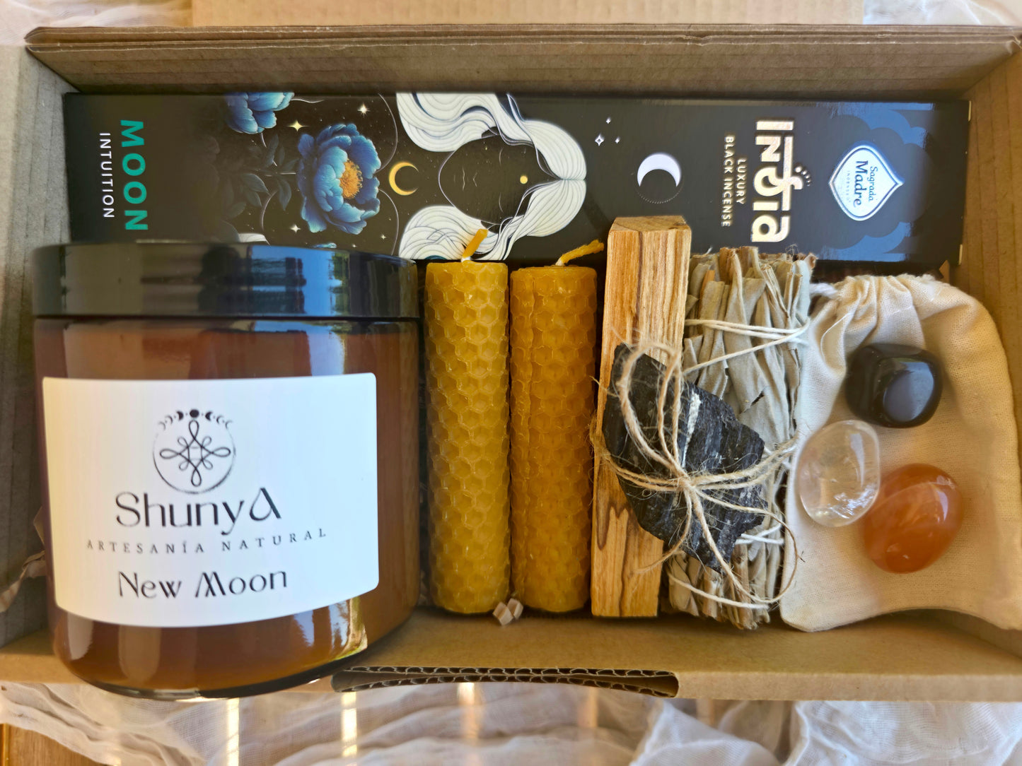 Detalle del pack Portal de Luna en su caja que contiene velas, incienso, sahumerio y minerales