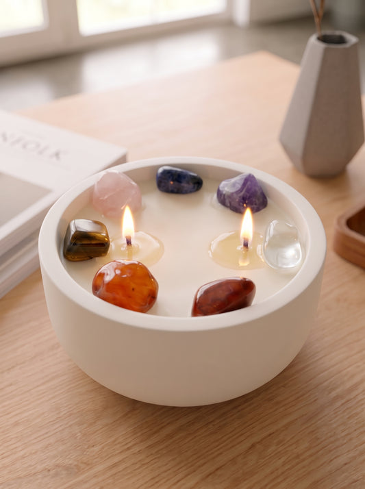 Detalle vela aromática Chakra Essence con 7 rodados que representan los 7 chakras encendida