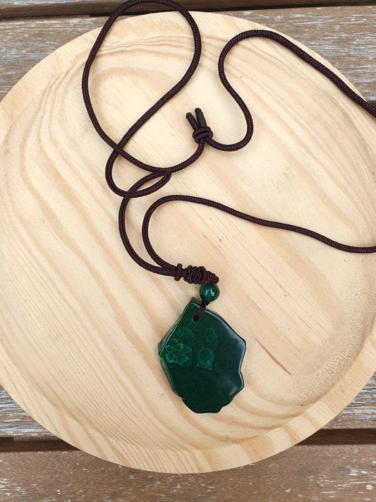 Colgante de Malaquita natural en rodaja bruta, piedra plana verde con vetas únicas y cordón negro ajustable.