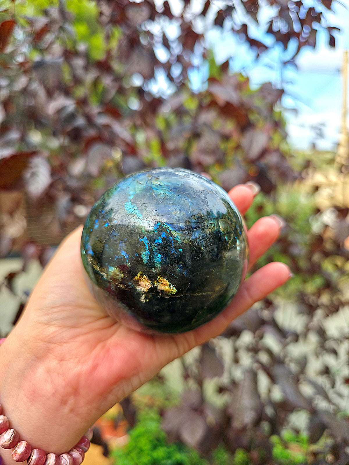 Primer plano de Esfera de labradorita natural mostrando destellos azules y dorados pieza 1