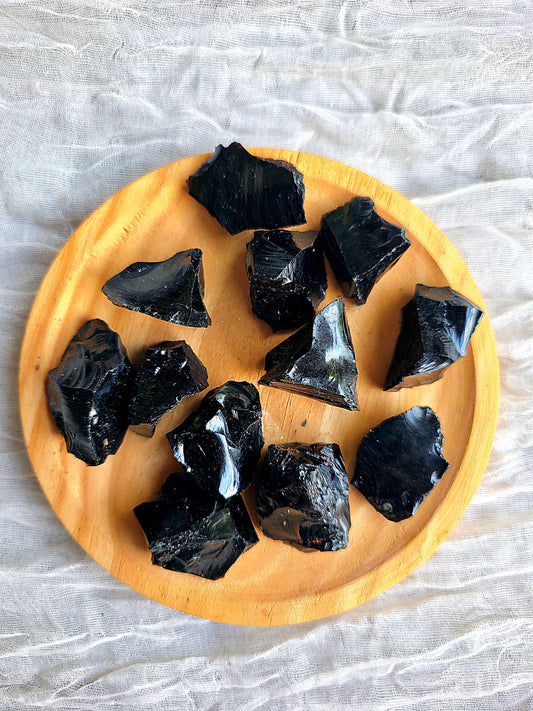 Pieza de obsidiana negra en bruto masivo mostrando su brillo natural y textura irregular.