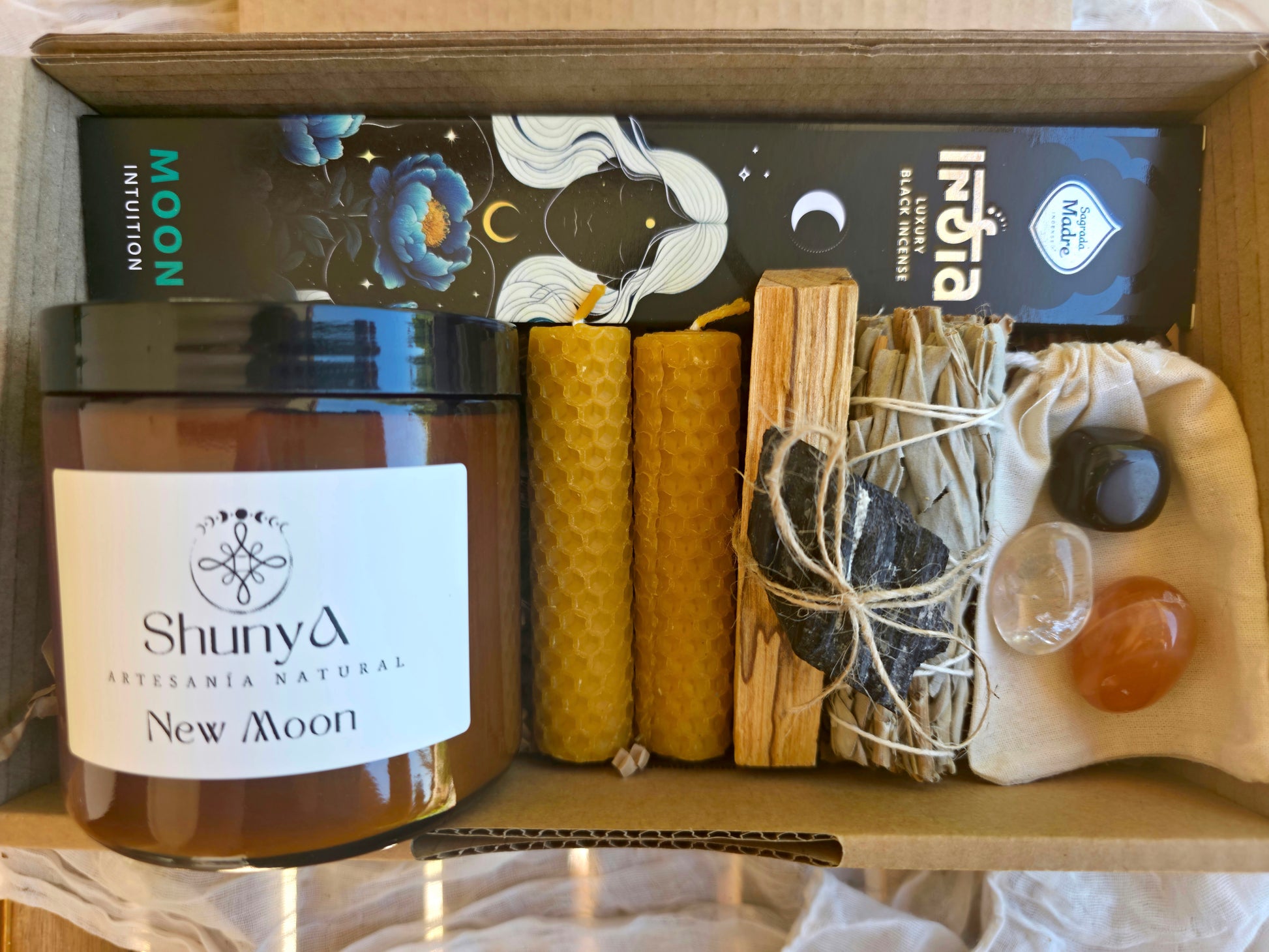 Detalle del pack Portal de Luna en su caja que contiene velas, incienso, sahumerio y minerales