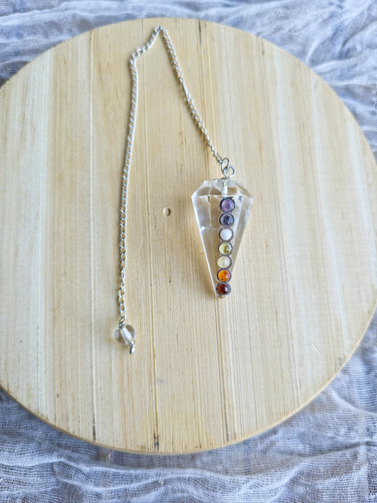 péndulo cuarzo cristal 7 chakras sobre fondo blanco