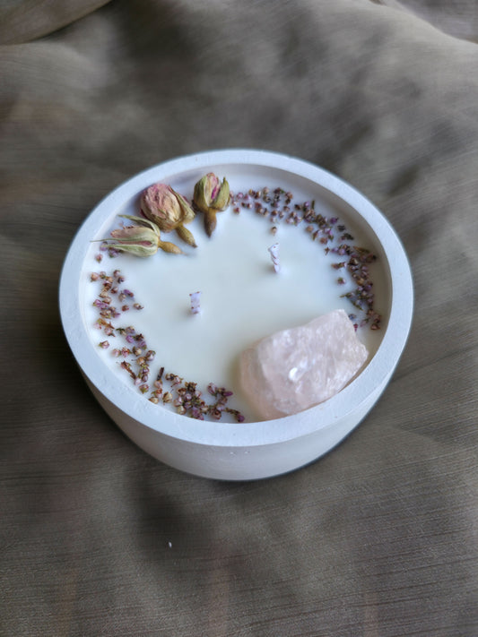 Detalle vela aromática Rose Quartz, con un masivo de cuarzo rosa y pétalos de rosas