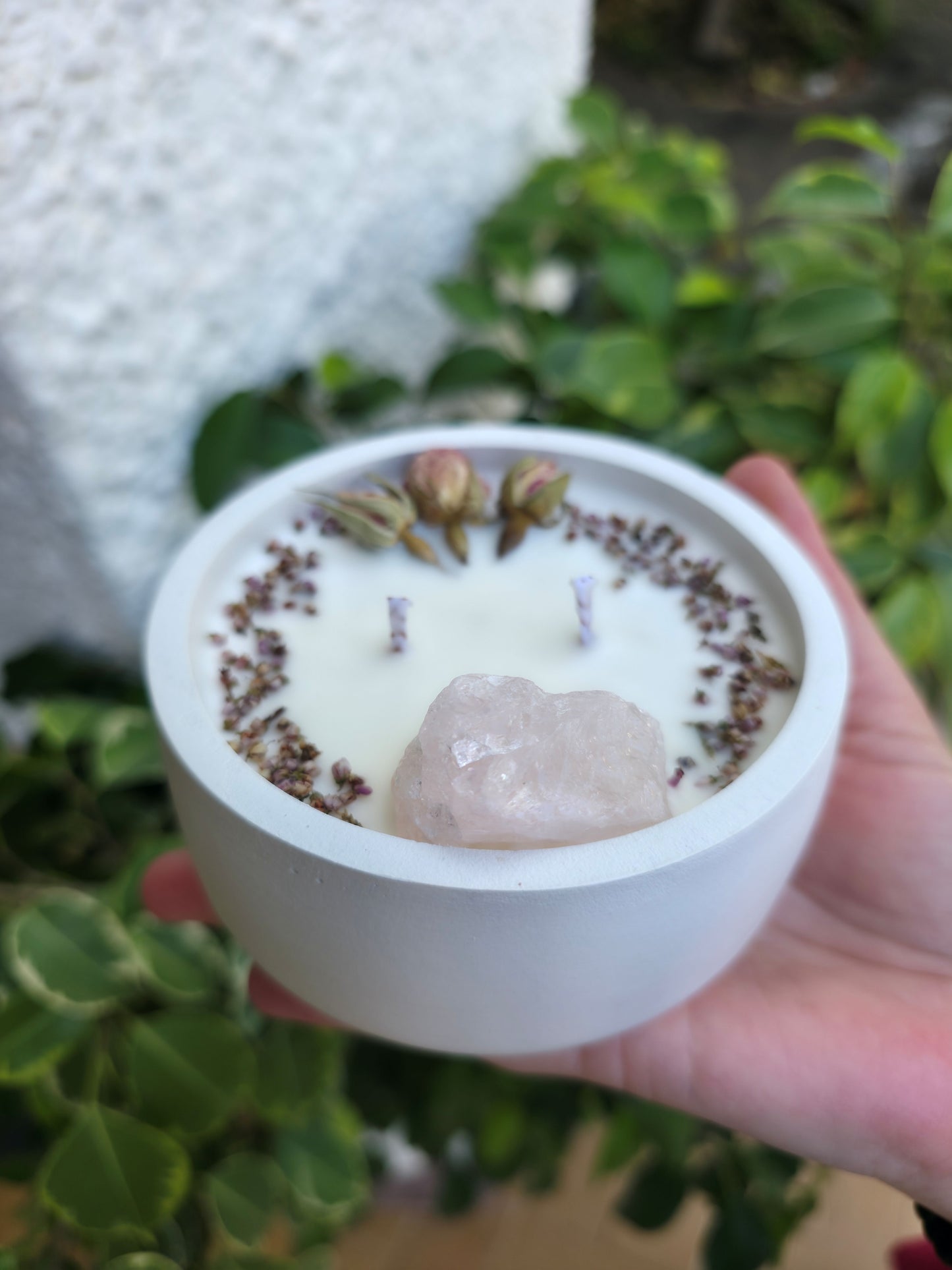 Vela aromática Rose Quartz con un masivo de cuarzo rosa y pétalos de rosas