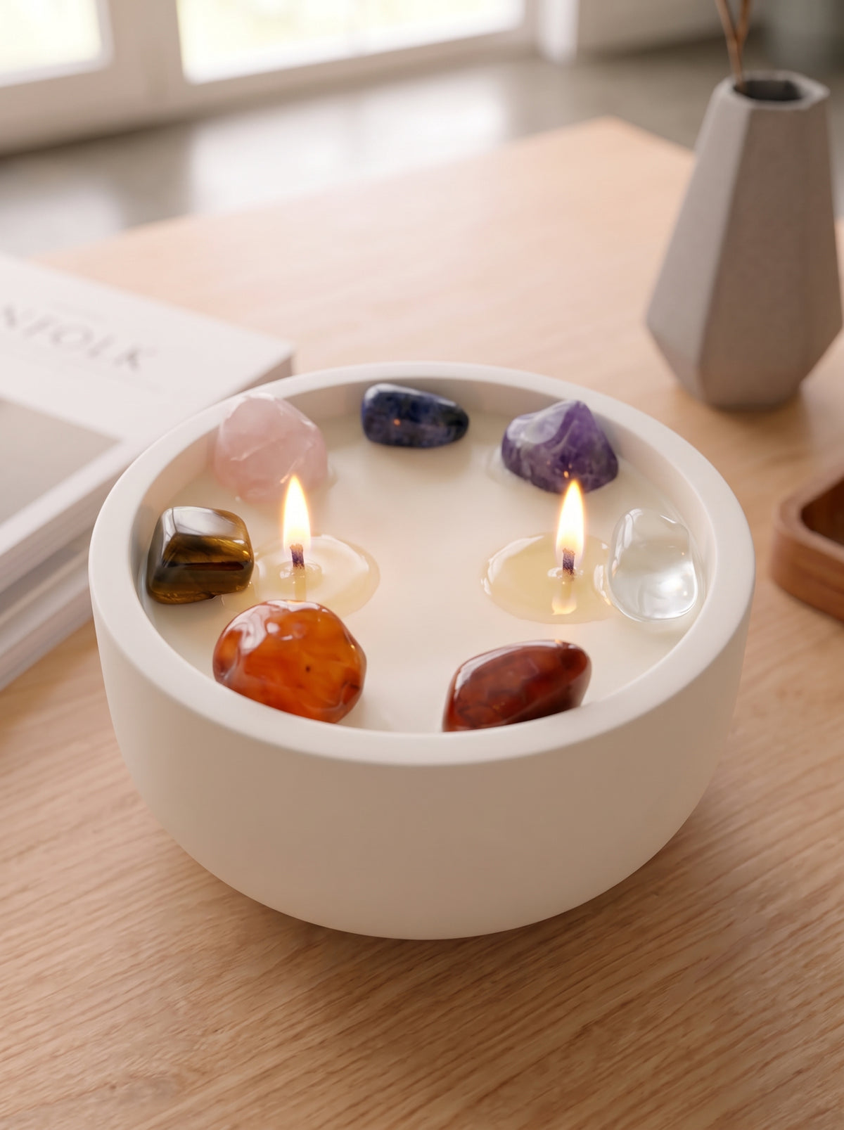 Detalle vela aromática Chakra Essence con 7 rodados que representan los 7 chakras encendida
